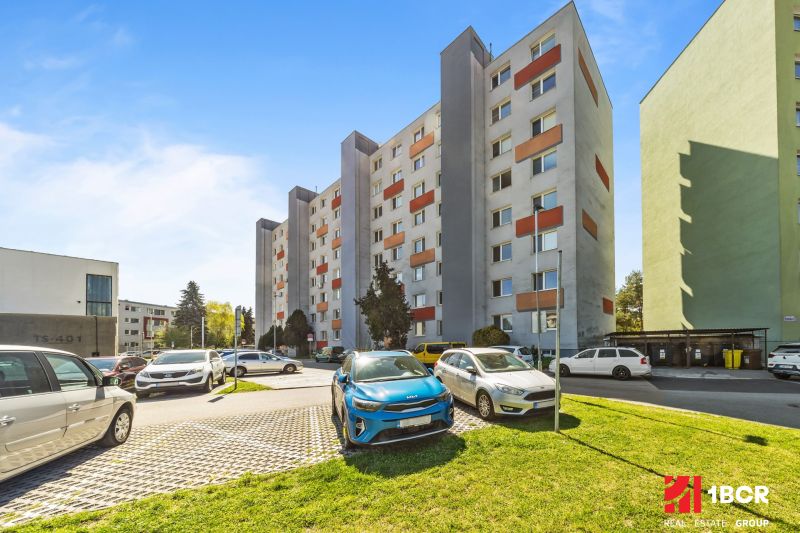 Apartment building on Estónska Street, Bratislava - Podunajské Biskupice, with a parking lot in front of the building.