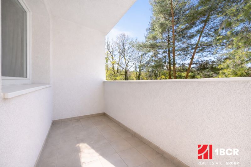 A balcony with a view of trees in a 3-room apartment.