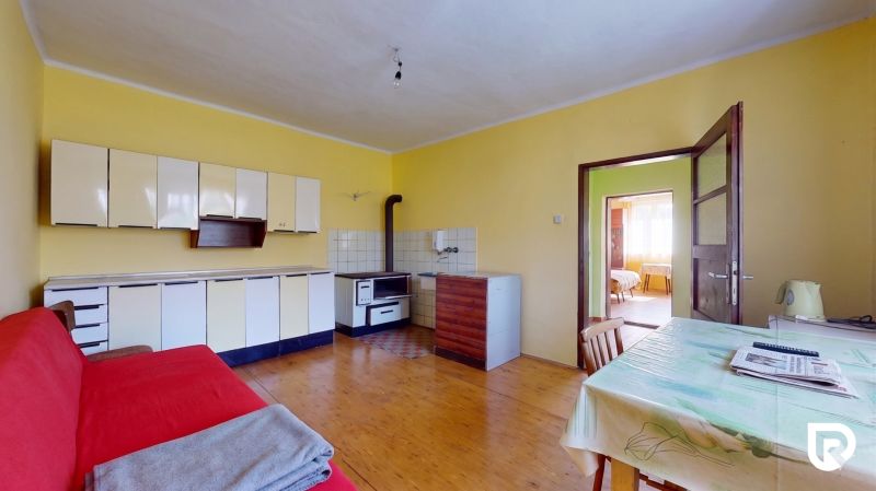A kitchen in a family house with furniture, a table, and a wooden decor floor.