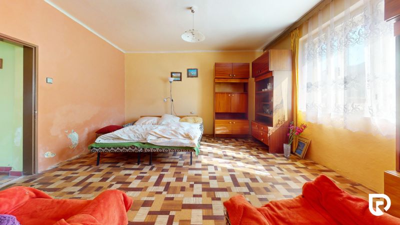 A bedroom with simple furnishings and a wooden decor floor in a family house.