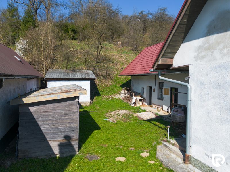 The courtyard of a family house in Dolná Poruba with a garden shed and a workshop.