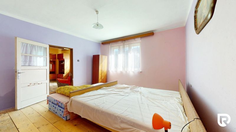 Bedroom in a family house with a wooden decor floor, pastel walls, bed.
