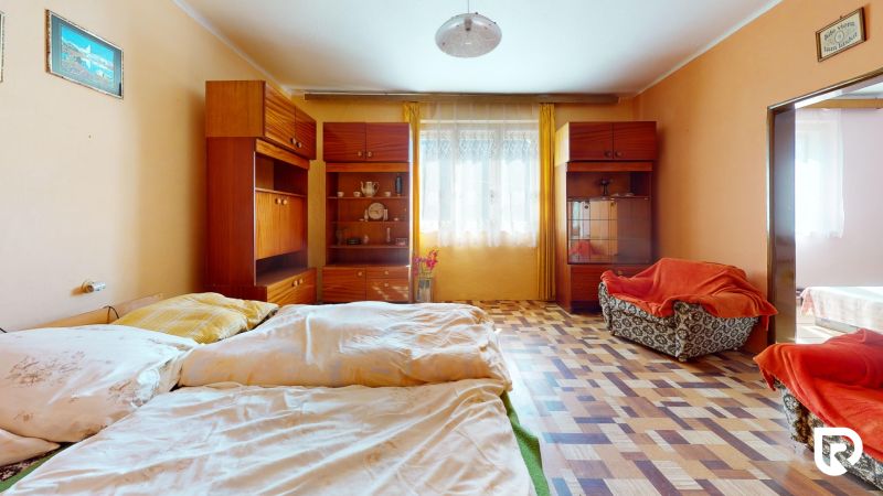 A bedroom in a family house with a wooden decor floor and vintage furniture.