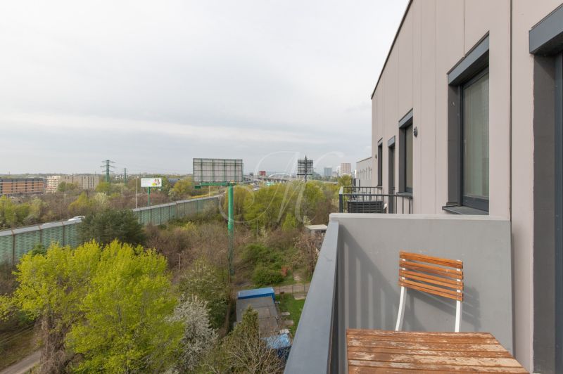 A balcony with a view of greenery and the road on Hraničná Street in Bratislava - Ružinov.