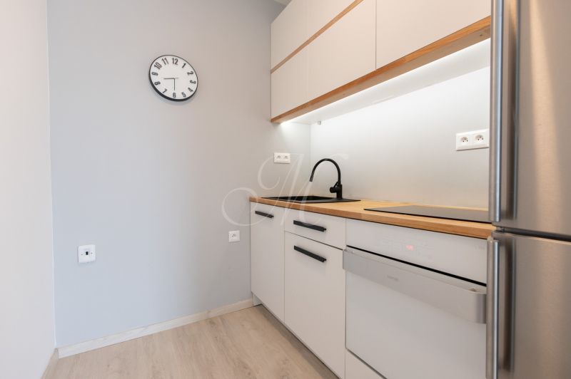 A kitchen in a 2-room apartment with a wooden decor and gray walls.
