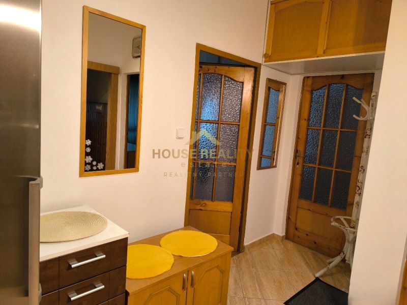 Interior of a 3-room apartment with glass doors and furniture in wood decor.