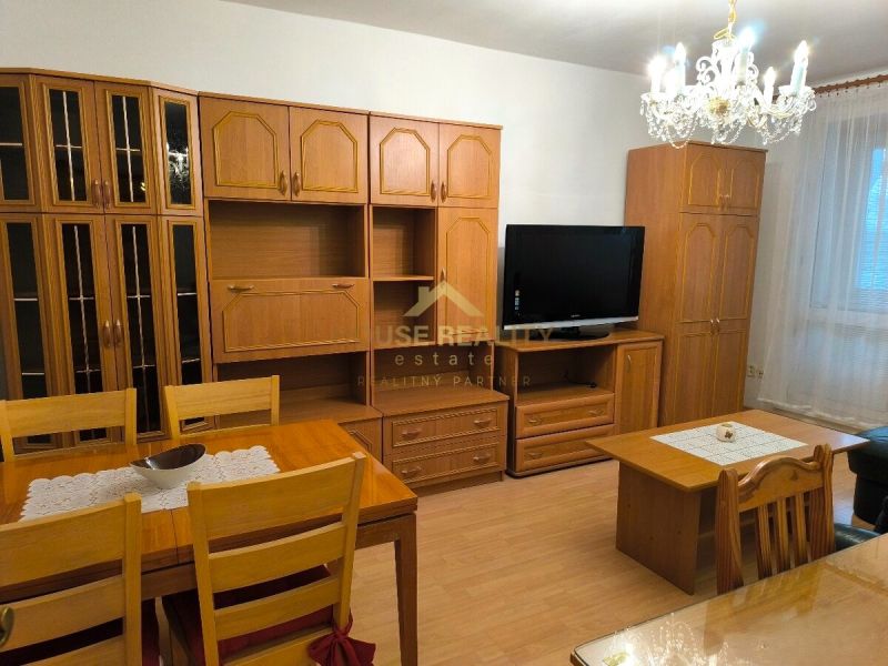 Living room in a 3-room apartment with wooden furniture and a chandelier, floor with wooden decor.