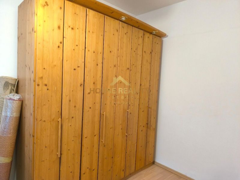 Wooden wardrobe in a 3-room apartment with a wooden decor floor.