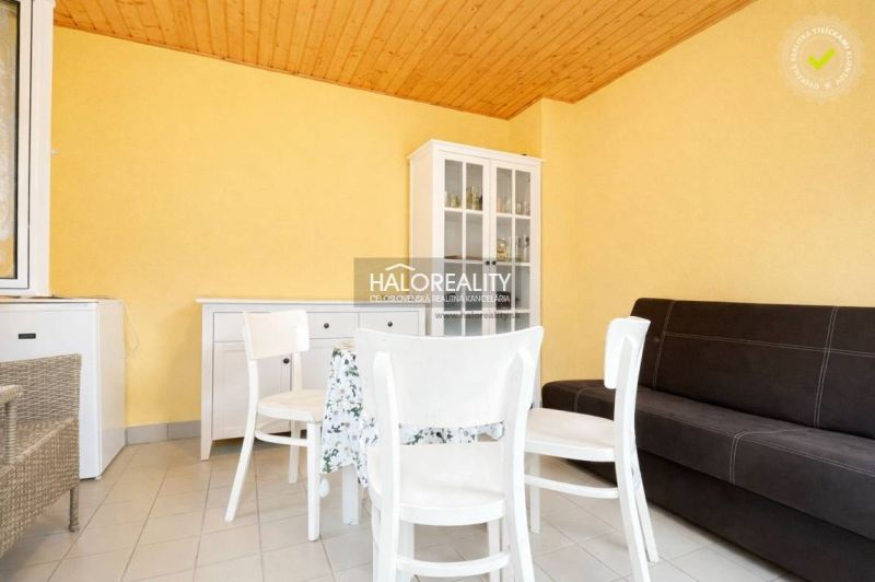 A table with chairs, a dresser, and a sofa in a room with yellow walls.