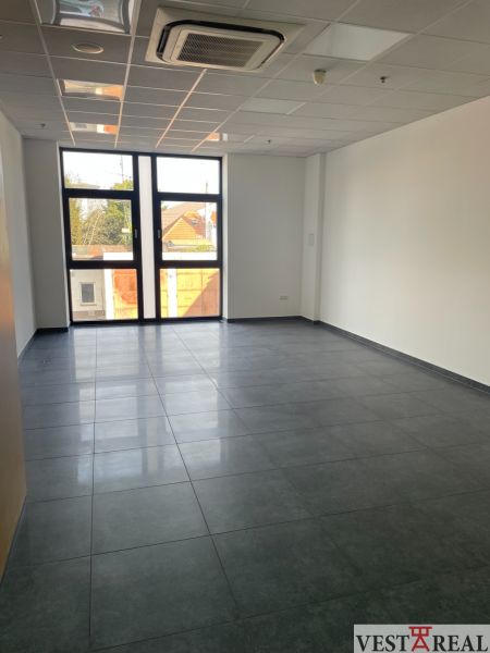 Interior of commercial spaces with tiling and a large window for natural light.