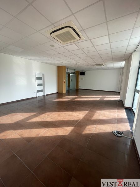 Commercial spaces with brown tiles and white walls, air conditioning on the ceiling.