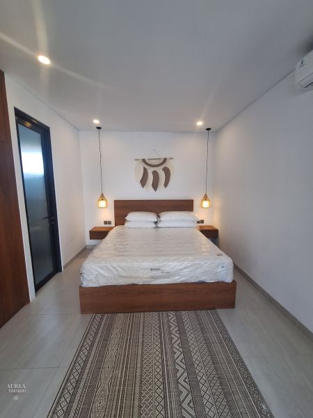 A room in a villa with a double bed and wall decoration.