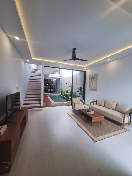 A living room in a villa with a pool and stylish furniture.
