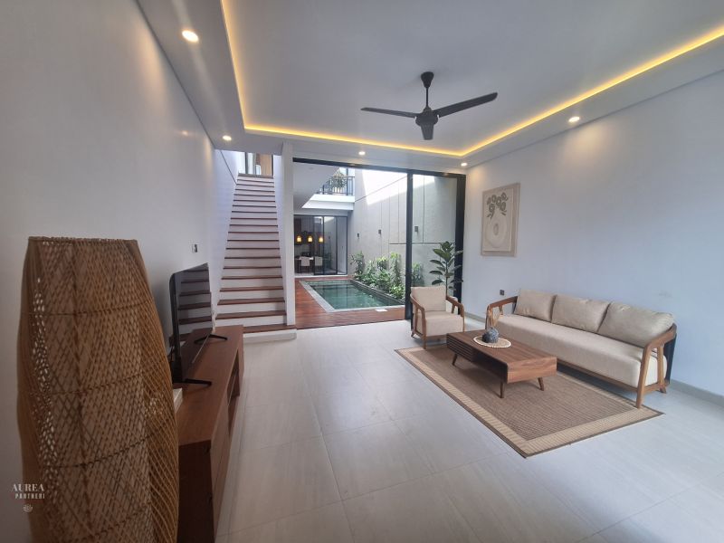 Living room in a villa with minimalist furniture and a view of the pool.
