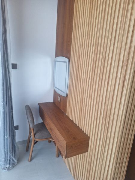 A wooden table with a chair and wooden wall decor in a villa room.