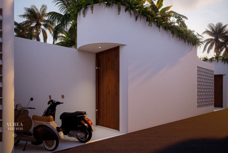 Entrance to the villa in Bali with motorcycles and vegetation on the wall.