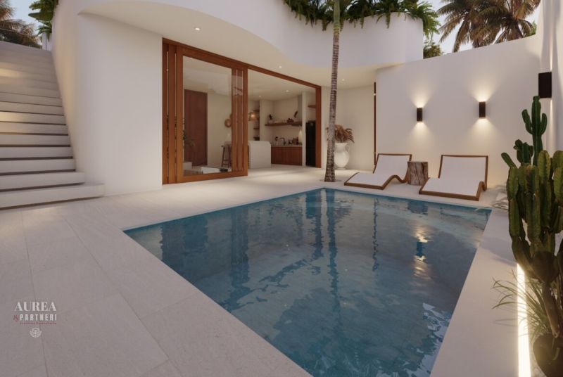 A pool in a villa in Bali with loungers and a staircase.