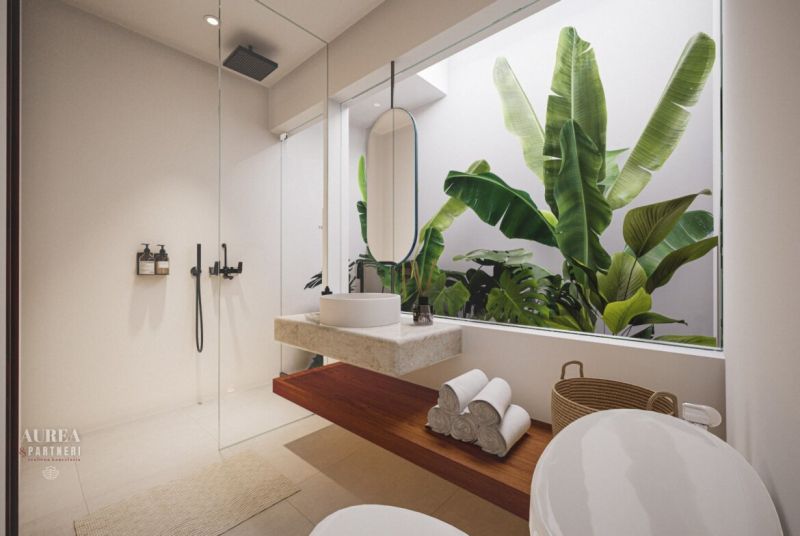 Bathroom in a villa with a glass wall and tropical plants, light colors and clean lines.