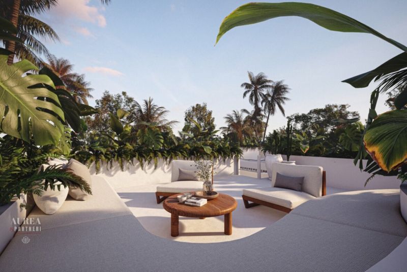 A villa in Bali with a spacious terrace, comfortable seating, and lush tropical greenery.