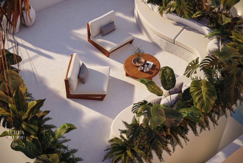 Terrace seating in a villa in Bali with comfortable chairs and a table surrounded by greenery.