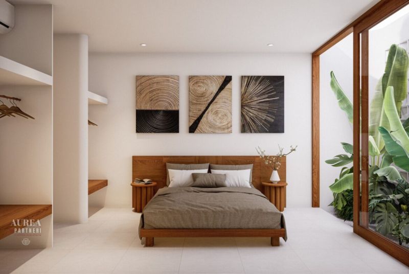 Interior of a villa with a bed, modern art, and large indoor plants.