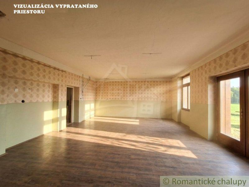 A spacious room in a family house with a wooden decor floor and large windows.