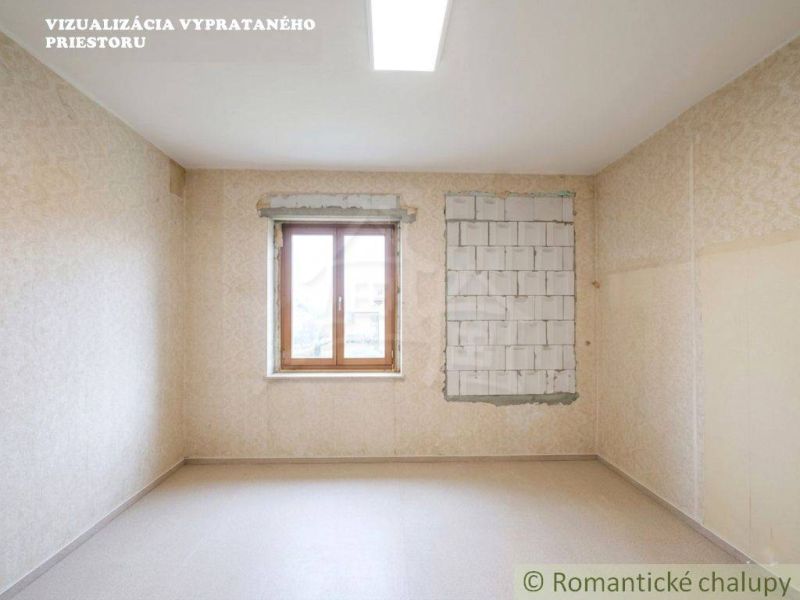 A room with wallpaper and a window in a family house, floor with wooden decor.