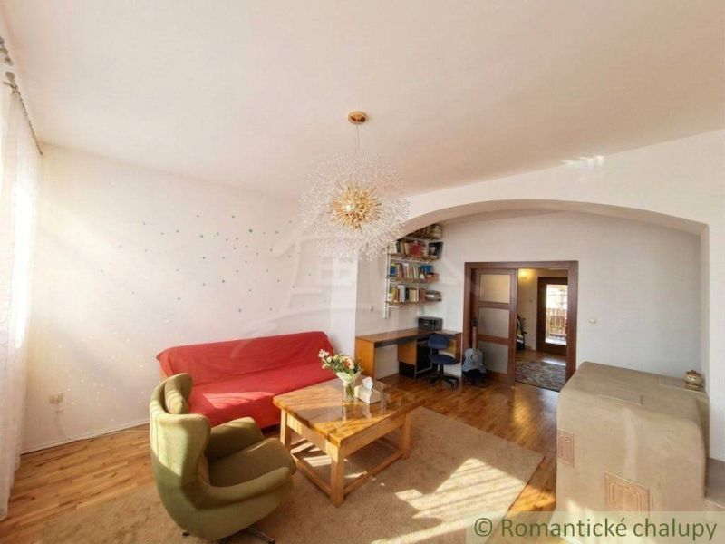 Living room in a family house with wood-patterned flooring, a sofa, and a workspace.