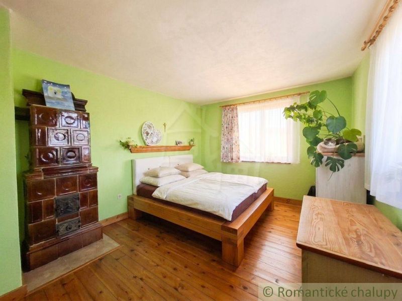 A bedroom in a family house with a stove and a floor with a wooden decor.