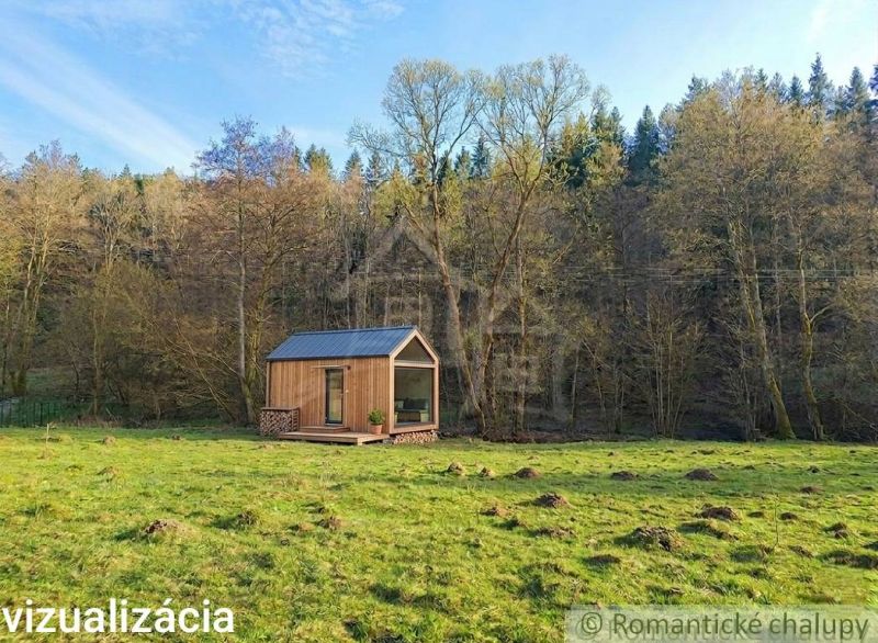 A small wooden house on a meadow surrounded by trees in the Gardens near Ľubietová.