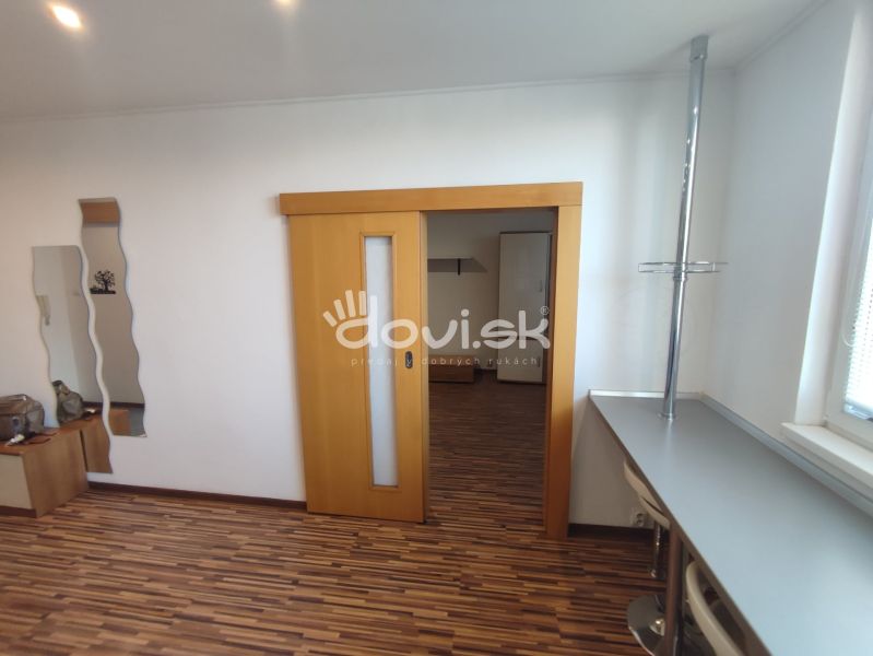 A one-room apartment with sliding doors and a wooden decor floor.