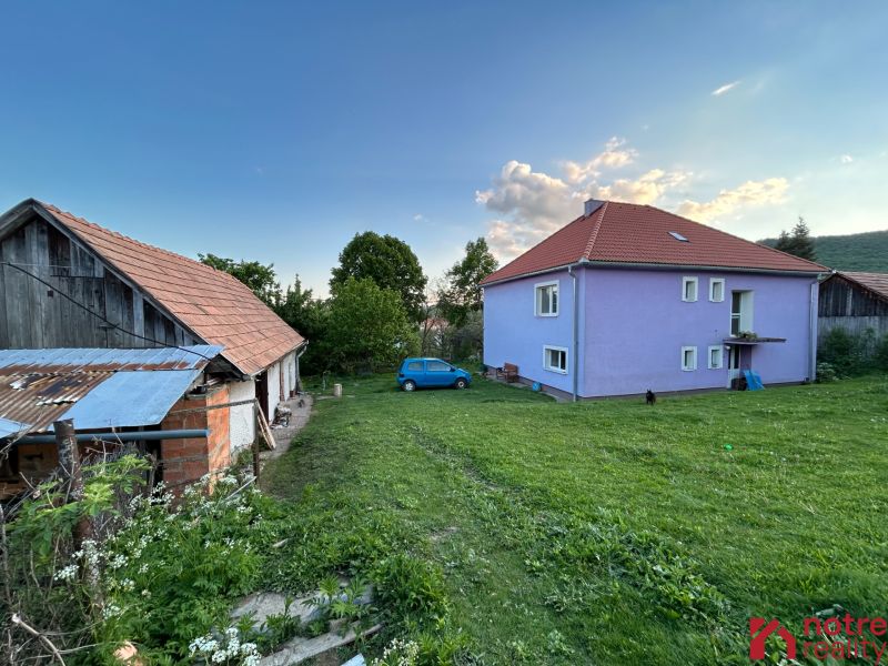 A family house in Kosihovce with a colorful facade, a large yard, and an adjacent farm building.