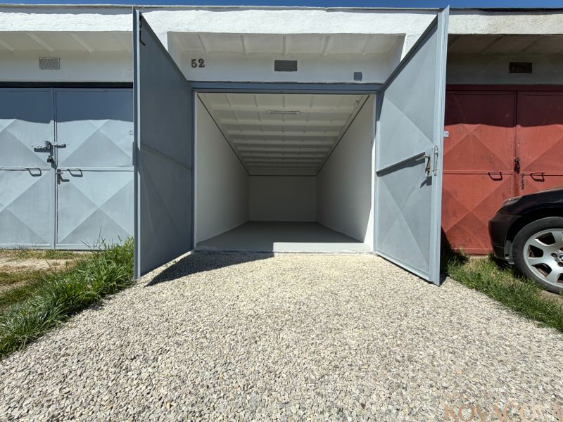 Open garage on Bezručova Street in Trenčín with a white interior and a gravel driveway.