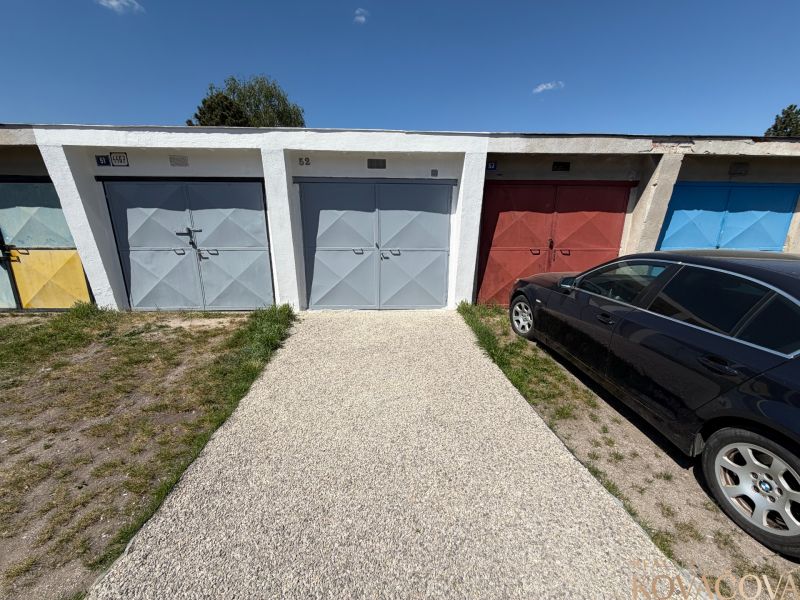 Garages on Bezručova Street in Trenčín with a car parked next to them on the grass.