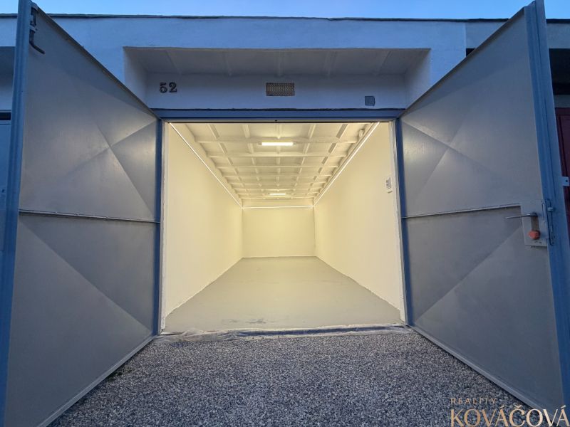 Open garage on Bezručova Street in Trenčín with a white interior and gravel surface.