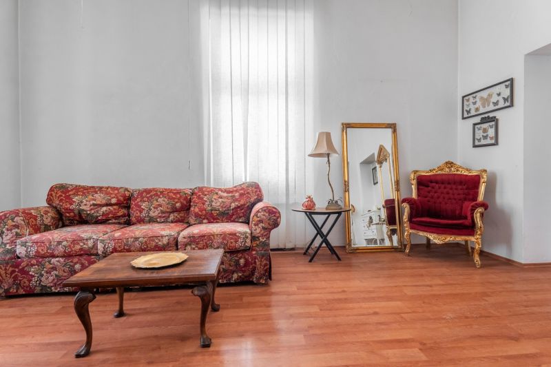 A stylish cottage interior with a floral sofa and a wooden decor floor.