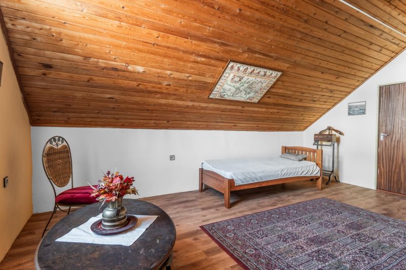 A cabin with a wooden floor decor, a bed, a carpet, and decorations.