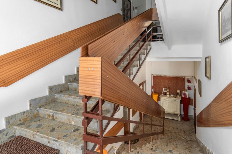 Staircase in a cabin with stone steps and wooden railing.