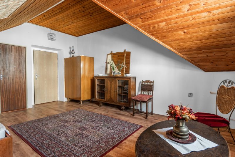 The interior of the cabin with a wooden ceiling, a floor with a wooden decor, and vintage furniture.