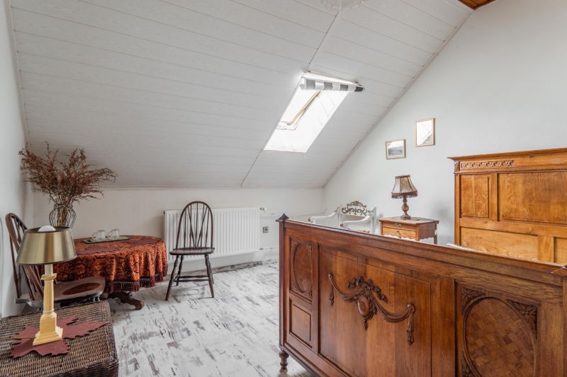 A room in a cottage with wooden furniture and a floor with a wooden decor.