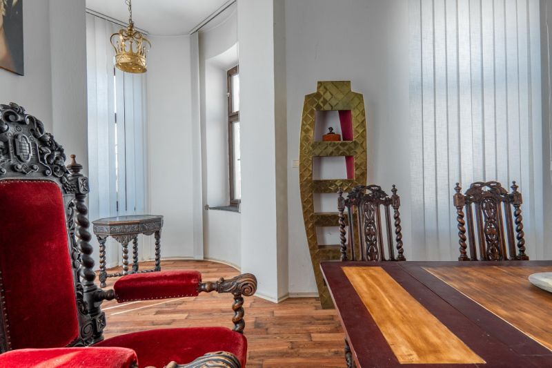 Interior of a cottage with historical furniture, wooden decor flooring, rich decorations.