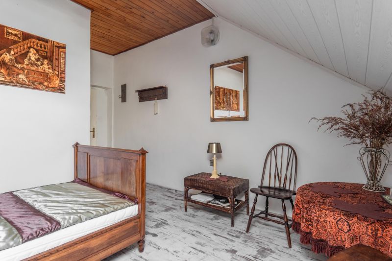 A room with wooden furniture, a floor with a wooden decor, and a decorative table in a cottage.