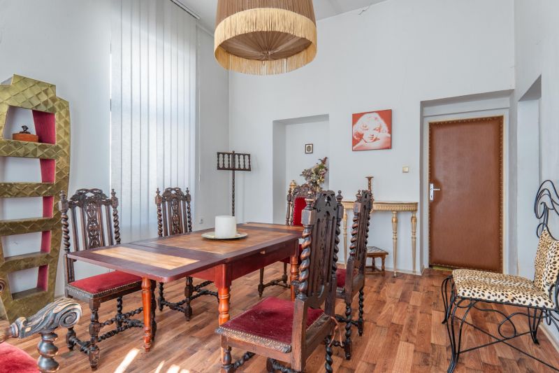 Dining area in a cabin with ornamental furniture and wood-patterned flooring.