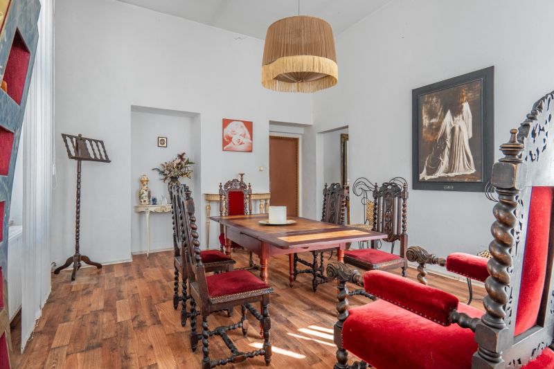 Dining room in a cottage with wooden chairs and a floor with a wooden decor.