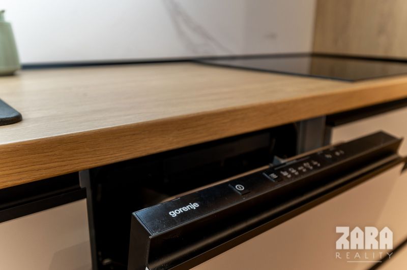 A built-in dishwasher with a wooden decor is installed in the kitchen of a 2-room apartment.