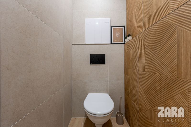 A small bathroom in a 2-room apartment with a striking wall and floor with a wood decor.