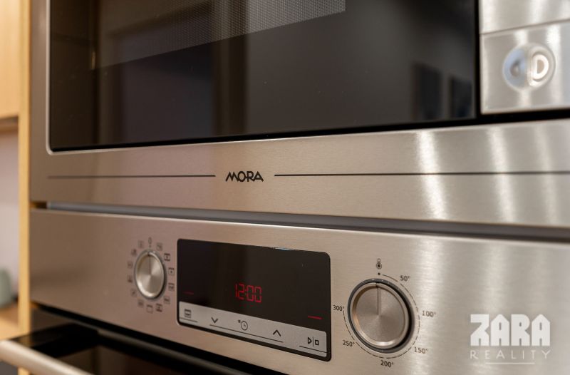 Details of kitchen appliances in a 2-room apartment with a stainless steel surface.