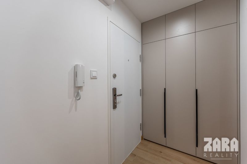 Hallway of a 2-room apartment with a built-in wardrobe and white walls.