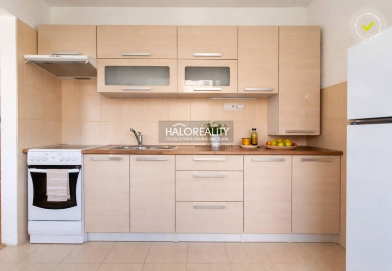 A kitchen in a studio apartment with wooden decor and a gas stove.
