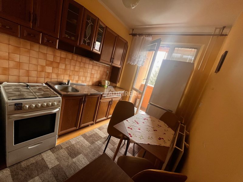 Kitchen in a 2-room apartment with a kitchen unit, stove, table, and chairs.